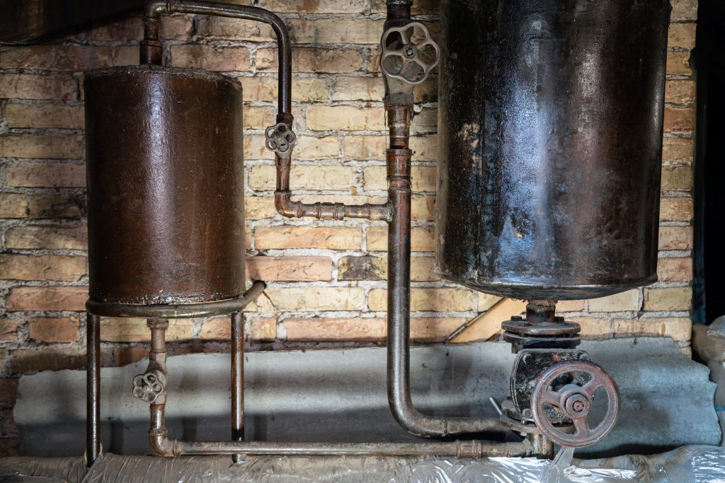 4 Signs that Your Water Heater Needs Replacement, Rusty boiler room pipes. Old metal boiler generating heating and delivering it to home through pipeline. Hot water or gas is being delivered with this system