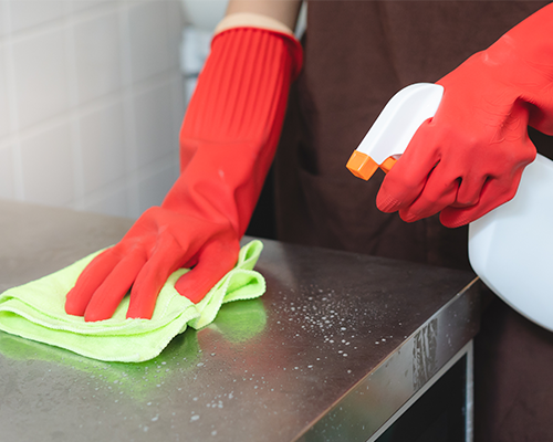 house maid cleaning sink in the kitchen with sponge and cleanser, stainless steel cleaning